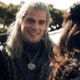 Henry Cavill as Geralt of Rivia in Netflix's The Witcher, smiling at Anya Chalotra's Yennefer.